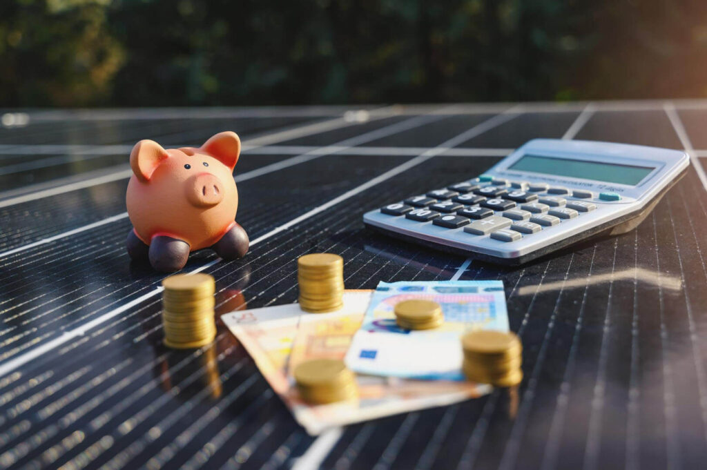 Cómo se desgravan las empresas placas solares: una calculadora y dinero encima de unas placas solares